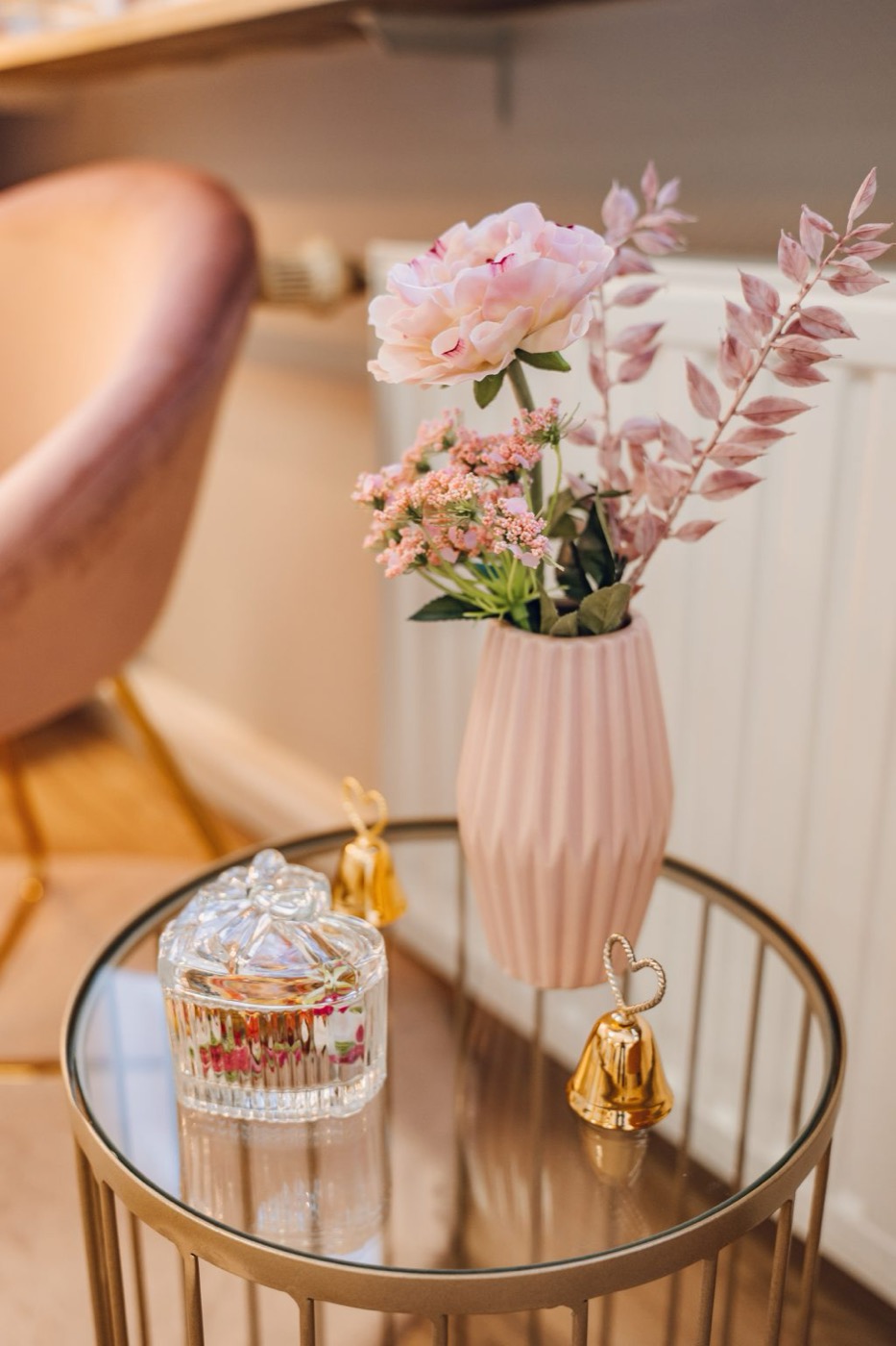 Liebevolle Details im Geschäft: Blumen und goldene Glöckchen auf einem Beistelltisch